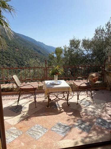 a table and chairs on a patio with a view at Villa Symbola in Oludeniz