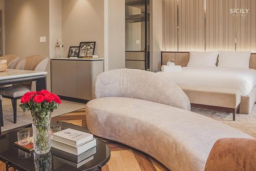 a hotel room with a bed and a couch and a table at Sicily Hotel Grand World Phú Quốc in Phú Quốc