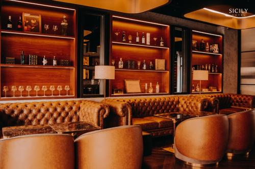 a bar with leather couches and tables at Sicily Hotel Grand World Phú Quốc in Phu Quoc