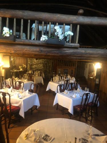a dining room with tables and chairs with white table settings at Garni degli Angioli in Ascona