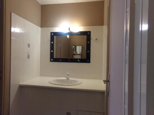 une salle de bain avec un lavabo et un miroir dans l'établissement Ashley Hôtel Le Mans Centre Gare, au Mans