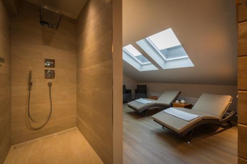 uma casa de banho com 2 cadeiras e um chuveiro com uma clarabóia em Hotel Lücke Rheine em Rheine