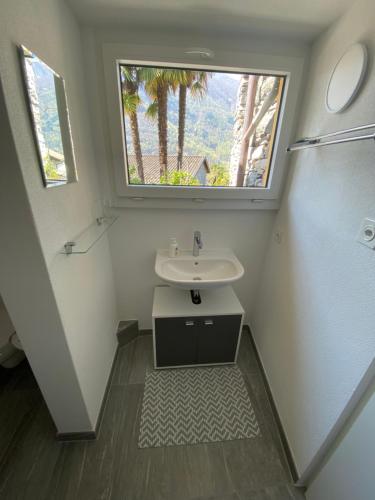 baño con lavabo y ventana en Rustico la Stalla, en Gordevio