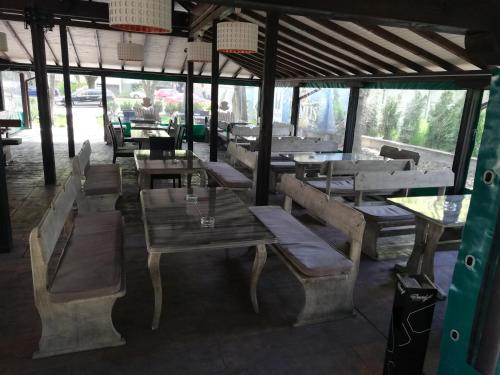 ヴィディンにあるHotel Pontiの木製のテーブル、ベンチ、テーブルが備わるレストラン