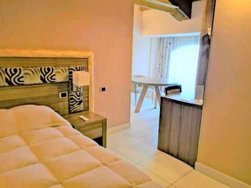 a bedroom with a bed and a table in a room at B&B Acireale - Il Cavalluccio Marino Fronte Mare in Acireale