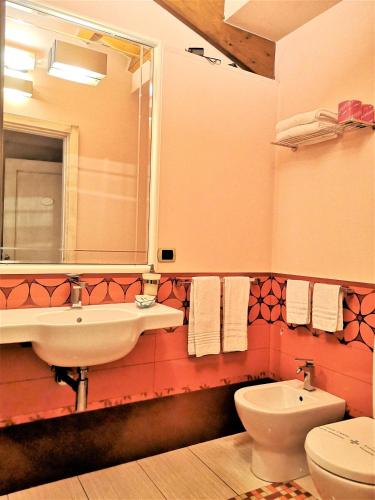 a bathroom with a sink and a toilet and a mirror at B&B Acireale - Il Cavalluccio Marino Fronte Mare in Acireale