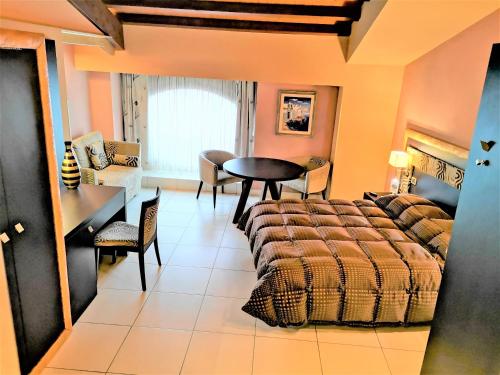 a bedroom with a bed and a table and chairs at B&B Acireale - Il Cavalluccio Marino Fronte Mare in Acireale
