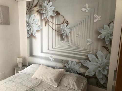 1 dormitorio con 1 cama con flores en la pared en GiorGiada, en Mazzeo
