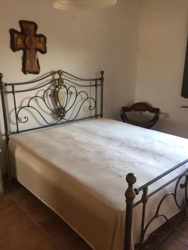1 dormitorio con 1 cama con una cruz en la pared en villa domenica, en Torre Squillace