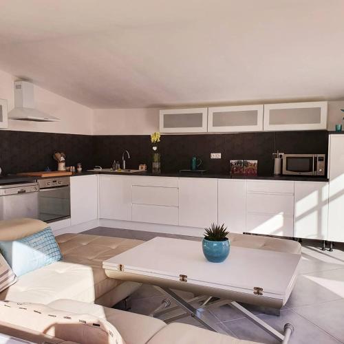 une cuisine avec des armoires blanches et une table dans l'établissement Villa les 2 Oliviers, au Luc