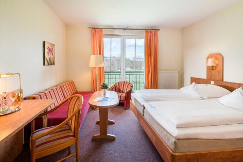 une chambre d'hôtel avec un lit, une table et des chaises dans l'établissement Wassermühle Heiligenthal, à Lunebourg