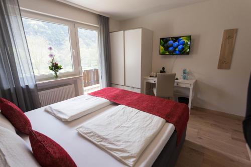Schlafzimmer mit einem Bett, einem Schreibtisch und einem Fenster in der Unterkunft Hotel Restaurant Sonnenlay in Kröv