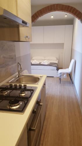a kitchen with a stove and a sink and a bed at Rocca Palazzaccio in Impruneta