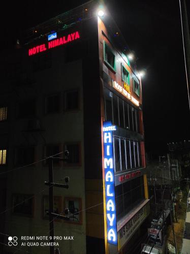a hotel with a neon sign on the side of a building at Hotel Himalaya in Agartala