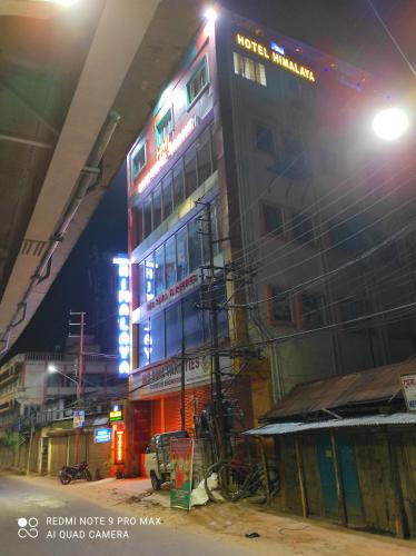 a building with neon signs on it at night at Hotel Himalaya in Agartala