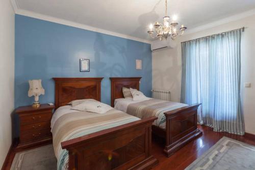 - une chambre avec 2 lits et un mur bleu dans l'établissement Guesthouse Pool & Sea Espinho Oporto, à Espinho