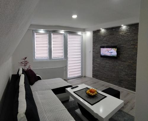 a living room with a couch and a table at Apartmani Zlatarski DAR in Nova Varoš