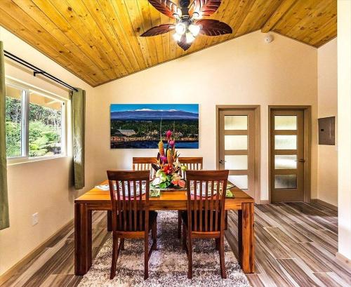 a dining room with a wooden table and chairs at Tropical Island Paradise home in Volcano