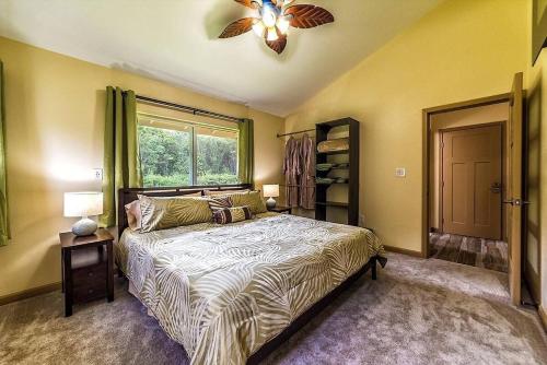 a bedroom with a bed and a ceiling fan at Tropical Island Paradise home in Volcano
