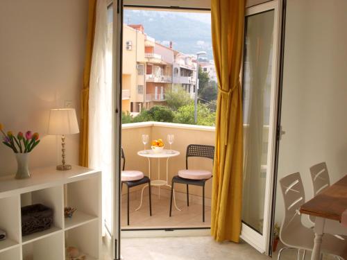 Apartments Dani želja في ماكارسكا: غرفة مع شرفة مع طاولة وكراسي