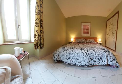 a bedroom with a bed and two windows at Les deux arches in Caunes-Minervois