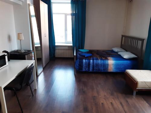 Schlafzimmer mit einem Bett, einem Schreibtisch und einem Fenster in der Unterkunft Hotel Admiral in Sankt Petersburg