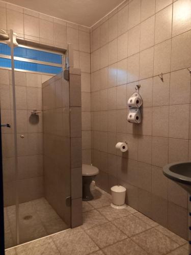 a bathroom with a shower and a toilet and a sink at Casa Caraguatatuba no Centro in Caraguatatuba
