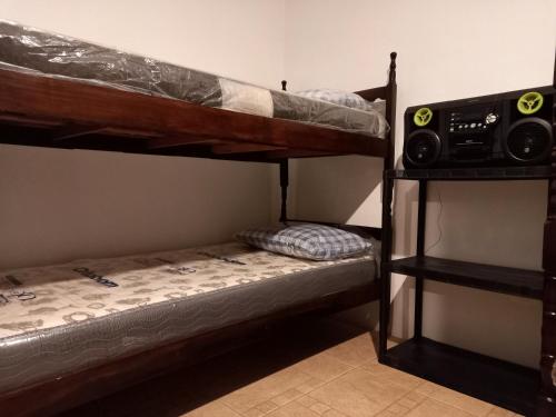 a bedroom with two bunk beds and a speaker at Casa Caraguatatuba no Centro in Caraguatatuba