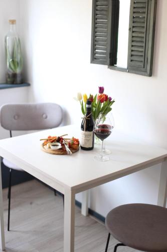 a white table with a bottle of wine and a glass at Bed and Wine Nonsolovino in Reeuwijk