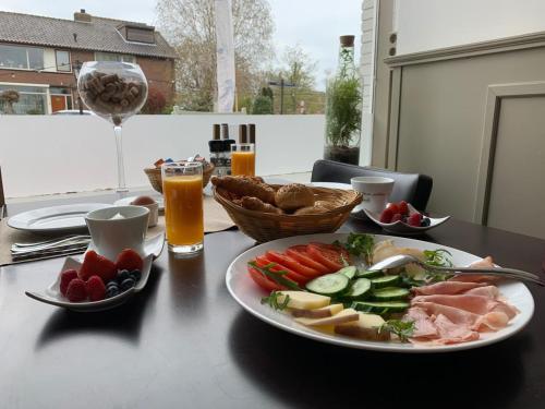a table with a plate of food on a table with drinks at Bed and Wine Nonsolovino in Reeuwijk