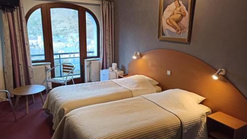 une chambre d'hôtel avec un lit et une fenêtre dans l'établissement Hotel Le Chalet, à La-Roche-en-Ardenne