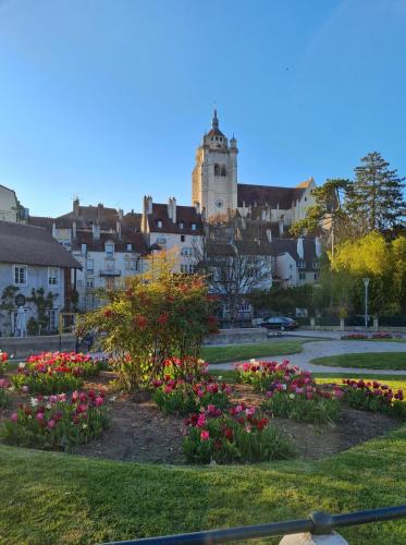 a park with flowers and a castle in the background at La Darbella - Style chalet de montagne in Dole