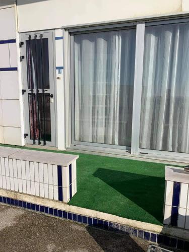 einen Balkon mit grünem Boden vor einem Gebäude in der Unterkunft Le bruit des vagues in Berck-sur-Mer