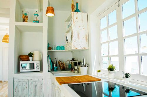 a kitchen with a sink and a microwave at Turquesa Beach&Pool Apartaments in Playa Honda