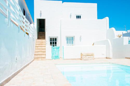 a swimming pool in front of a white building at Turquesa Beach&Pool Apartaments in Playa Honda