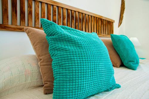 two blue pillows sitting on a bed with at Turquesa Beach&Pool Apartaments in Playa Honda