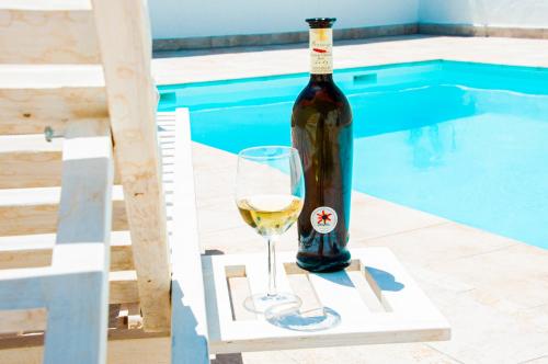 a bottle of wine and a glass next to a pool at Turquesa Beach&Pool Apartaments in Playa Honda