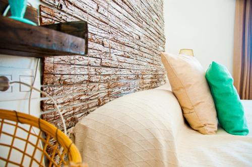 a brick wall behind a couch with a pillow at Turquesa Beach&Pool Apartaments in Playa Honda
