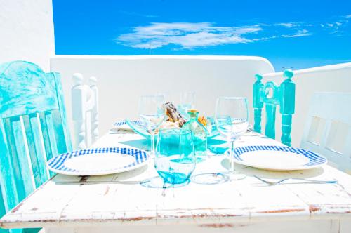 a table with wine glasses and plates on it at Turquesa Beach&Pool Apartaments in Playa Honda