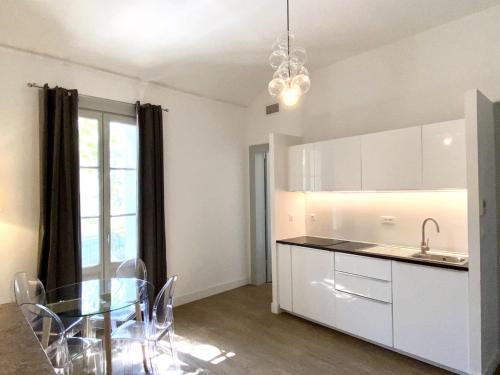 een keuken met een tafel en een glazen tafel en een eetkamer bij T2 Montpellier centre, climatisé in Montpellier
