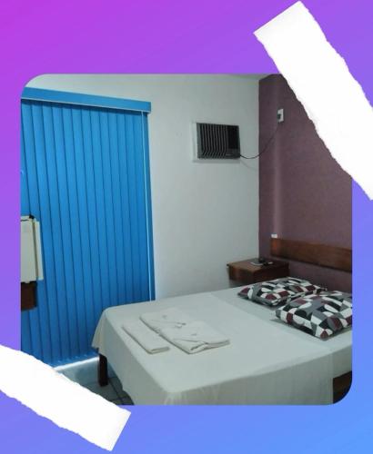 a bedroom with a bed and a blue door at Pousada Oceano Azul in Guarapari