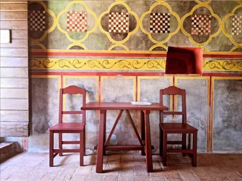 a wooden table with two chairs and a laptop on it at Agriturismo Castello Di Belforte in Todi