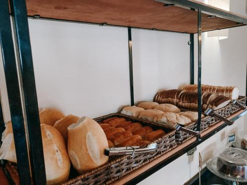a shelf filled with lots of different types of bread at Pousada Vale Valparaíso Inn- Polo gastronômico in Petrópolis