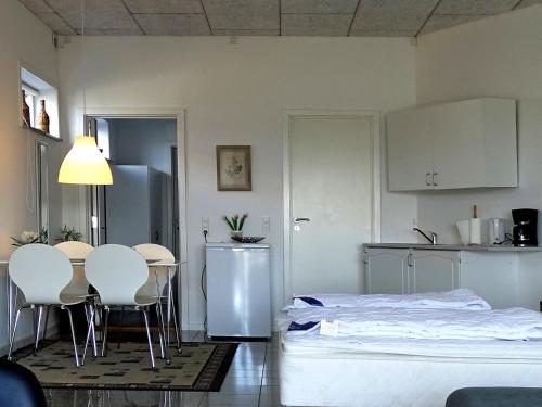 ボーゲンセにあるBogense Ferieboのベッド、テーブル、椅子が備わる客室です。