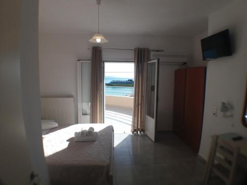 a bedroom with a bed and a view of the ocean at Harbour View - Oceanis Apartments in Poros