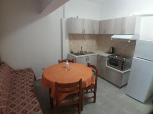a small kitchen with a table and a sink at Harbour View - Oceanis Apartments in Poros