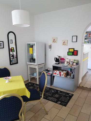 a dining room with a yellow table and chairs at Garni Elisabetta in Gordola