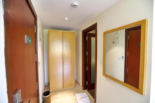 un corridoio con specchio e porta in una stanza di Zip By Spree Hotels Hyde Goa a Goa Velha