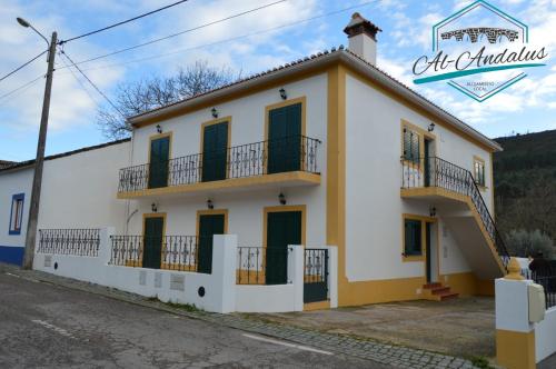 a white and yellow building with a balcony at Al-Andalus Alojamentos in Marvão