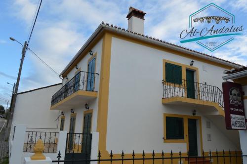 a white building with a fence in front of it at Al-Andalus Alojamentos in Marvão